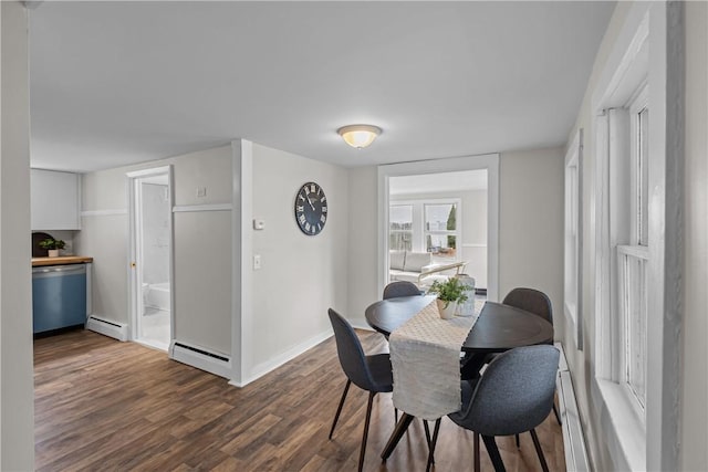 dining space featuring dark wood-type flooring, a baseboard heating unit, and baseboards