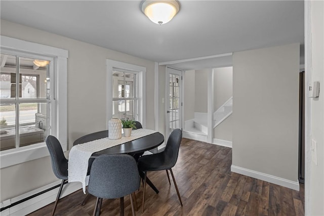 dining area with stairway, dark wood-type flooring, a baseboard radiator, and baseboards