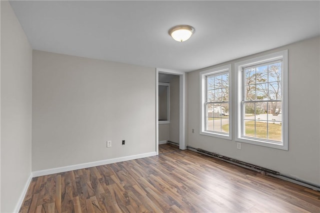 spare room featuring baseboards and wood finished floors