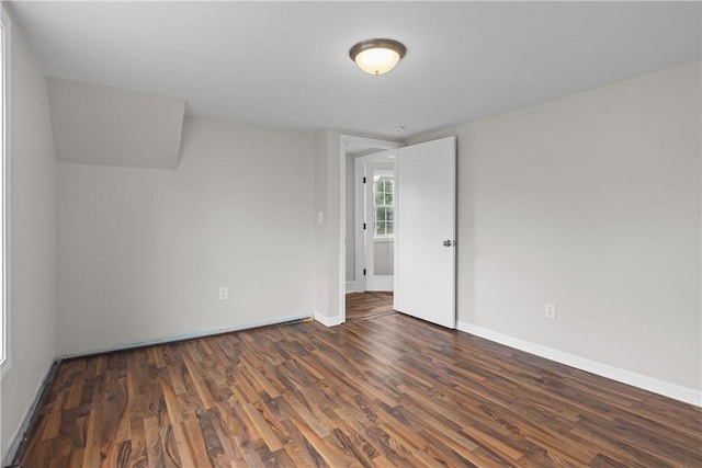 spare room featuring baseboards and wood finished floors
