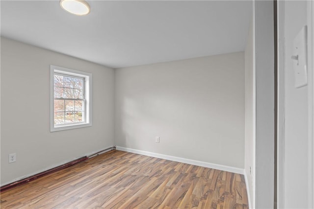 unfurnished room featuring wood finished floors and baseboards