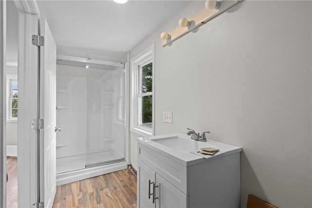 bathroom featuring a shower stall, vanity, and wood finished floors
