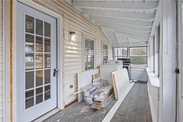 sunroom / solarium featuring beamed ceiling and washer / dryer