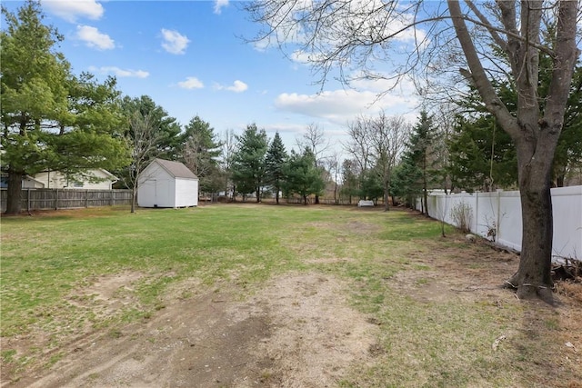 view of yard featuring a storage shed, an outbuilding, and a fenced backyard