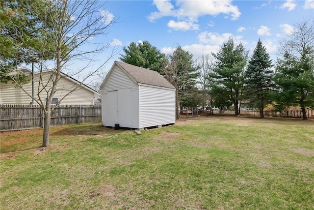 view of yard featuring an outbuilding, a storage unit, and a fenced backyard