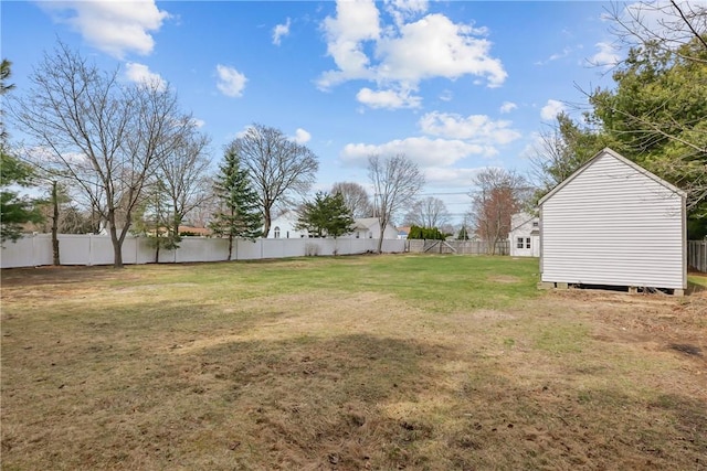 view of yard with a storage shed, a fenced backyard, and an outdoor structure