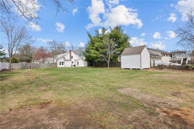 view of yard featuring a shed, a fenced backyard, and an outdoor structure