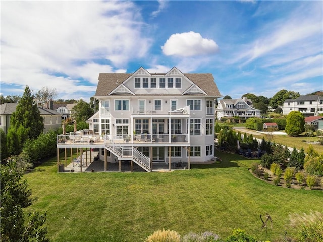 rear view of property with a yard, stairway, and a deck