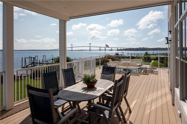 deck featuring outdoor dining area and a water view