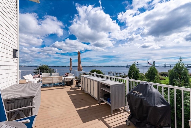 deck with a grill, a water view, and outdoor lounge area