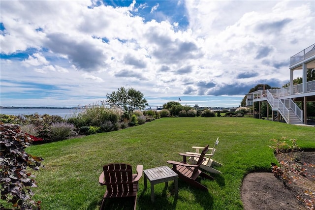 view of yard featuring a water view and stairs