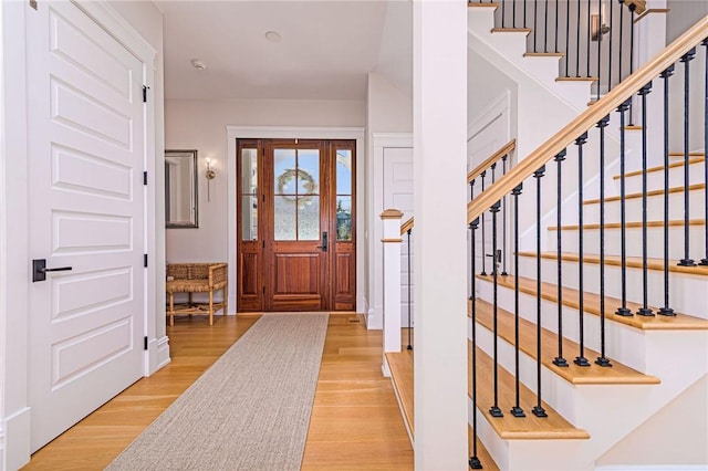 entrance foyer featuring stairs and light wood-style floors