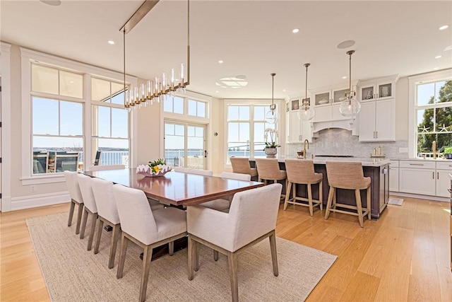 dining area with light wood finished floors and recessed lighting