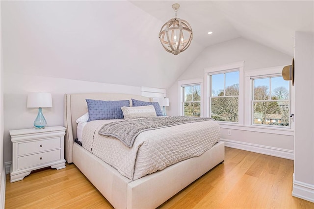 bedroom featuring light wood finished floors, baseboards, a chandelier, and lofted ceiling