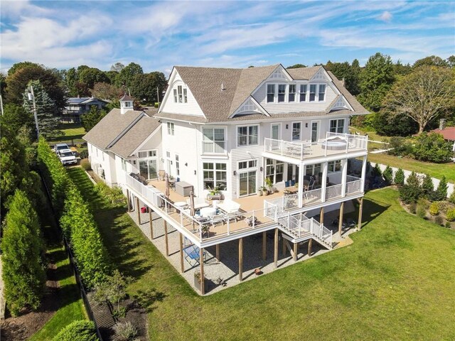 10 Coulter St, Jamestown, RI 02835 - rear view of house with a balcony, a shingled roof, a lawn, and stairs