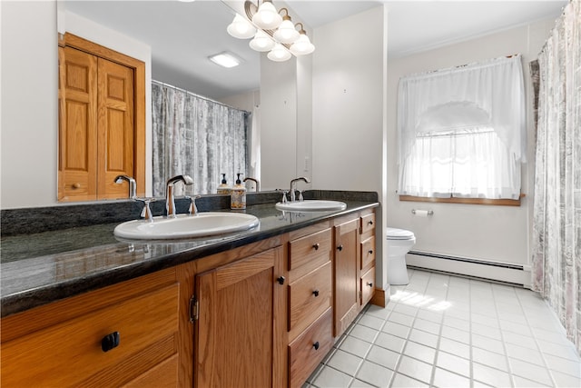 200 Pond St, South Kingstown, RI 02879 - bathroom with double vanity, baseboard heating, a sink, and toilet