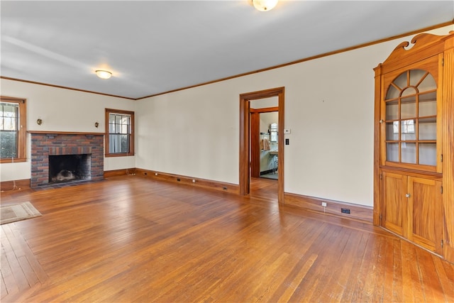 200 Pond St, South Kingstown, RI 02879 - unfurnished living room with hardwood / wood-style floors, a brick fireplace, crown molding, and baseboards
