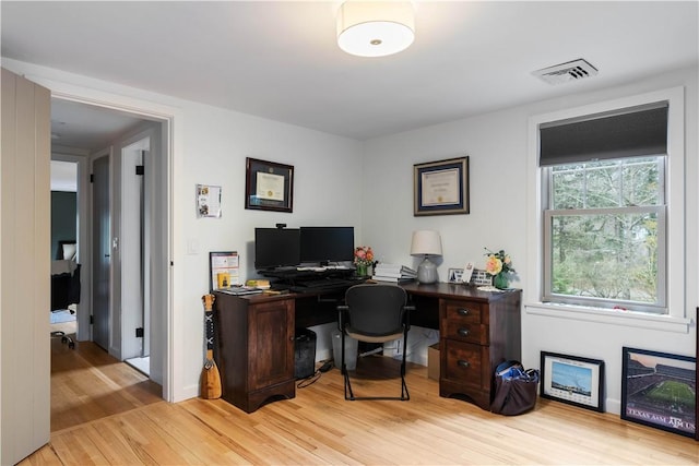 office with light wood-style floors and visible vents