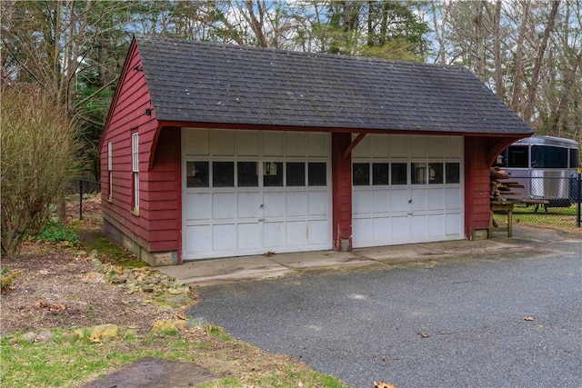 detached garage featuring fence