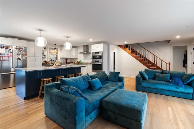 living room with light wood finished floors, recessed lighting, and stairs