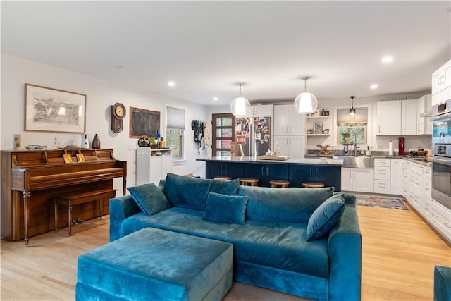 living room with light wood-type flooring and recessed lighting
