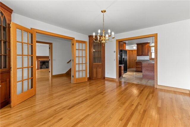 200 Pond St, South Kingstown, RI 02879 - unfurnished dining area featuring light wood-style flooring, an inviting chandelier, baseboards, and stairway