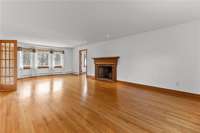 200 Pond St, South Kingstown, RI 02879 - unfurnished living room featuring a brick fireplace, light wood-type flooring, and baseboards