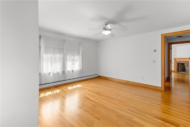 200 Pond St, South Kingstown, RI 02879 - unfurnished room with ceiling fan, a fireplace, wood finished floors, a baseboard radiator, and baseboards