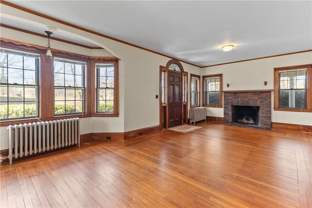 200 Pond St, South Kingstown, RI 02879 - unfurnished living room with a wealth of natural light, radiator, and hardwood / wood-style floors
