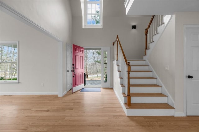foyer with light wood-style flooring, plenty of natural light, and stairs