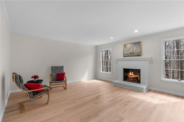 sitting room featuring baseboards, ornamental molding, and wood finished floors