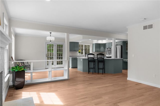 interior space with baseboards, a chandelier, crown molding, light wood-style floors, and visible vents