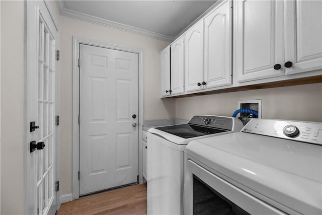 clothes washing area with cabinet space, ornamental molding, washer and dryer, and light wood-style floors