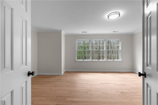 unfurnished room with light wood finished floors, baseboards, and ornamental molding