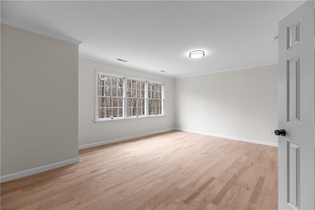 empty room featuring ornamental molding, baseboards, and light wood finished floors