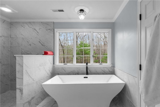 full bathroom with visible vents, a freestanding tub, tile walls, crown molding, and tiled shower