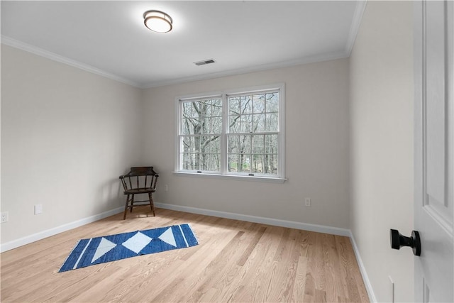 unfurnished room with wood finished floors, baseboards, ornamental molding, and visible vents