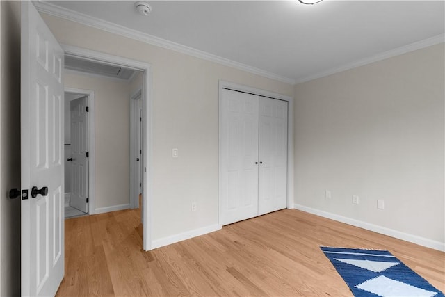 unfurnished bedroom featuring a closet, light wood-style flooring, baseboards, and ornamental molding