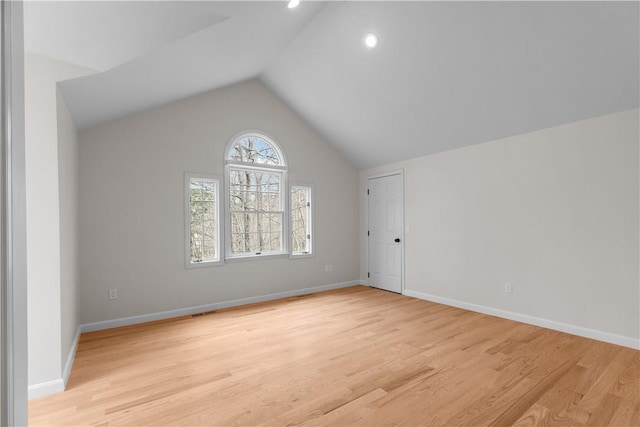 interior space featuring light wood-type flooring, baseboards, and lofted ceiling