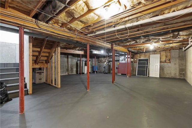 unfinished basement featuring stairway and heating unit