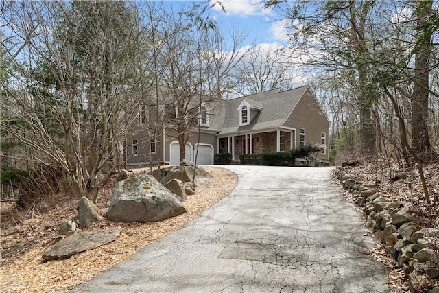 cape cod-style house featuring aphalt driveway and an attached garage