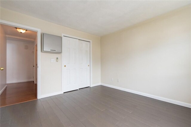 83 Wyndham Ave, Providence, RI 02908 - unfurnished bedroom featuring a closet, dark wood-style flooring, and baseboards