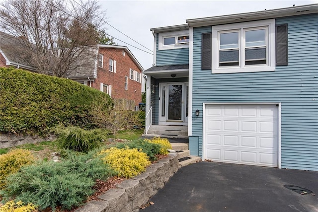 83 Wyndham Ave, Providence, RI 02908 - view of front of house with driveway, a garage, and fence