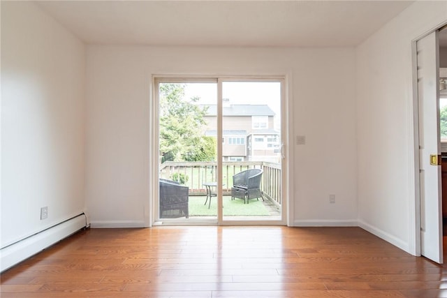 83 Wyndham Ave, Providence, RI 02908 - empty room with wood finished floors, a baseboard heating unit, and baseboards