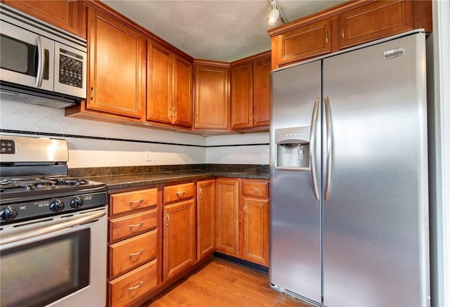 83 Wyndham Ave, Providence, RI 02908 - kitchen featuring brown cabinets, dark countertops, and stainless steel appliances
