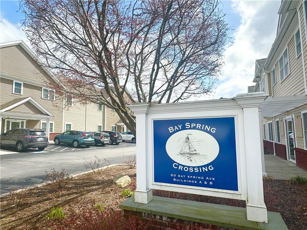 community / neighborhood sign featuring uncovered parking
