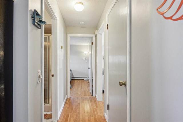 hall with light wood-style floors, baseboards, and a baseboard radiator