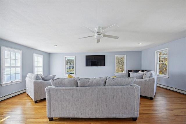 living room with ceiling fan, a baseboard radiator, baseboard heating, and wood finished floors