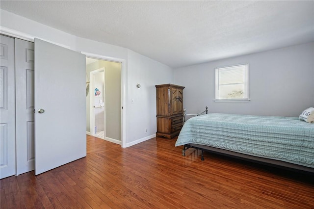 bedroom with a closet, wood-type flooring, and baseboards