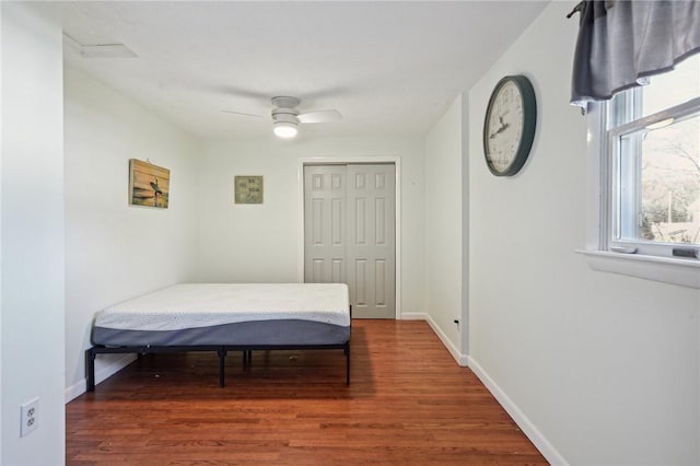 bedroom with a closet, baseboards, ceiling fan, and wood finished floors